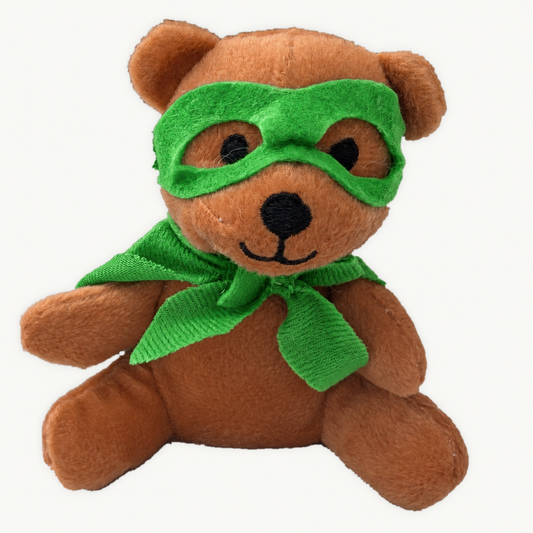 Brown plush teddy wearing a green superhero mask and cape on a light background