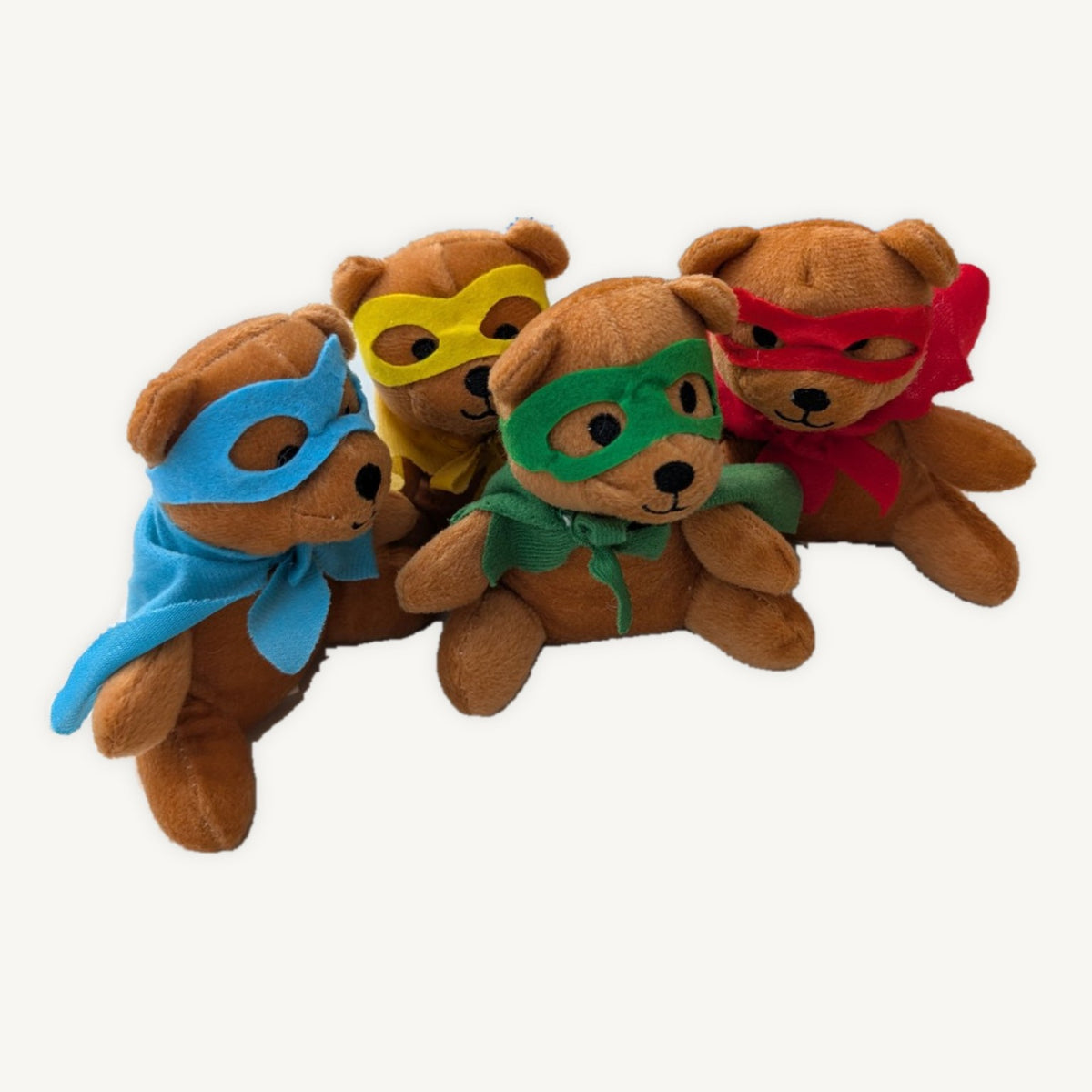 Four brown plush superhero teddies in blue, yellow, green and red masks and capes, posed together on a light background