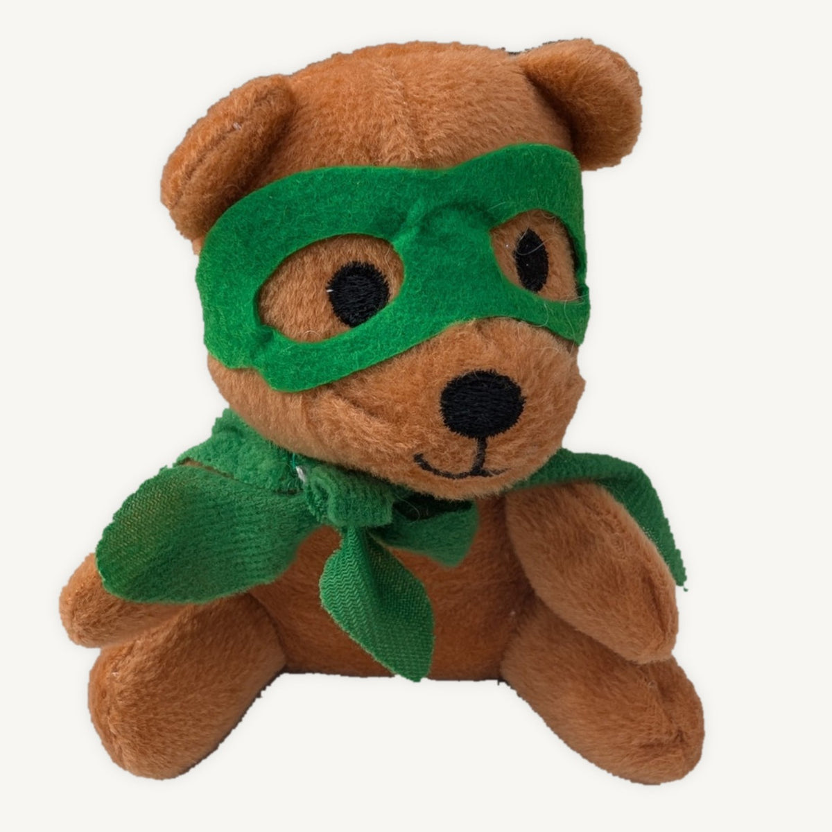 Brown plush teddy wearing a green superhero mask and cape, shown seated against a light background