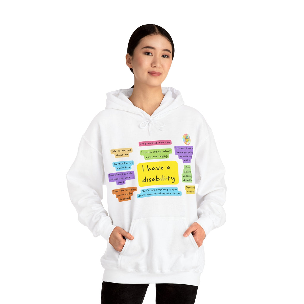 Adult model wearing white I Have a Disability hoodie with colourful front print and R. M. Rayner logo